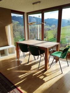 Urlaub in Alberschwende في البيرشوينده: طاولة وكراسي في غرفة مع نافذة كبيرة
