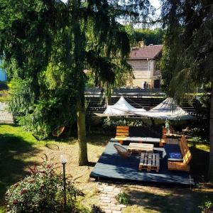 een tuin met een bank en stoelen onder een boom bij Red Chapel in Łagów