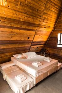 a bedroom with two beds in a wooden ceiling at Pousada Al Mare Beach in Luis Correia