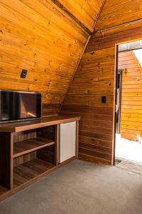 een kamer met een tv en een houten muur bij Pousada Al Mare Beach in Luis Correia