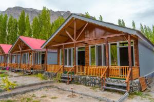 a row of cottages with mountains in the background at Greenwood Resort Skardu in Skardu