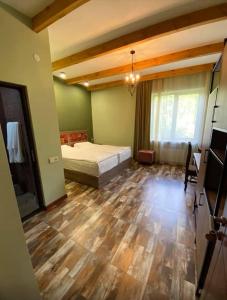 a bedroom with a bed and a wooden floor at Kefilyan Family Hotel in Haghpat