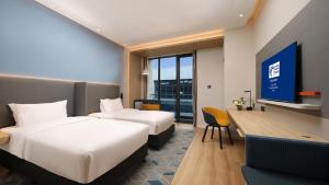Habitación de hotel con 2 camas y TV en Holiday Inn Express Dalian Golden Pebble Beach, an IHG Hotel en Dalian