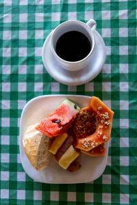 un piatto di cibo su un tavolo con una tazza di caffè di Pousada Al Mare Beach a Luis Correia