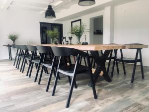 a large wooden table with black chairs in a room at Red Chapel in Łagów