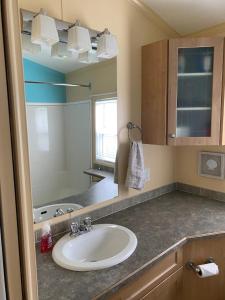 a bathroom with a sink and a mirror at Beaver Lake Resort Site #36 in Lake Cowichan