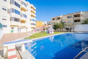 a swimming pool in front of a apartment building at Solbelo Quarteira Beach in Quarteira