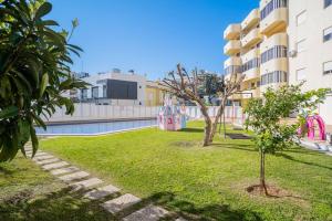a park in front of a building with a playground at Solbelo Quarteira Beach in Quarteira