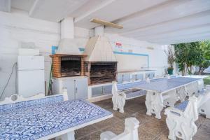 a patio with a table and chairs and a grill at Solbelo Quarteira Beach in Quarteira