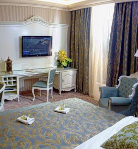 um quarto de hotel com uma cama, uma secretária e cadeiras em Savoy Hotel em Chisinau