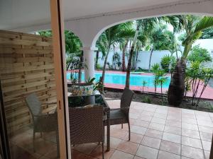 a patio with a table and chairs and a pool at Artists house in Rivière Noire