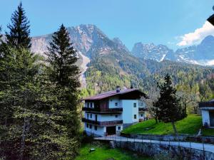 una casa en una colina con montañas en el fondo en Il Terrazzo Sulle Dolomiti, en Cibiana