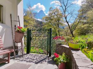 a gate to a garden with flowers on a patio at Il Terrazzo Sulle Dolomiti in Cibiana