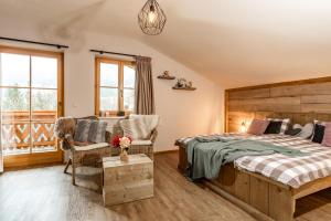 a bedroom with a bed and a chair at Piekvier lodge in Schladming