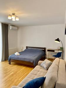 ein Wohnzimmer mit einem Bett und einem Sofa in der Unterkunft Cozy apartment next to the park in Ternopil