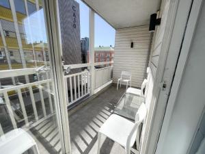 a balcony with white chairs and a glass table at City Center Royal Pallace in Oslo