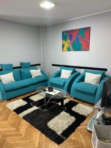 uma sala de estar com dois sofás azuis e um tapete em M&G centar grada em Pozarevac