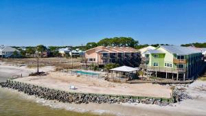 a group of houses on the beach next to the water at Sandcastle 6G - Dauphin Island Real Estate in Dauphin Island
