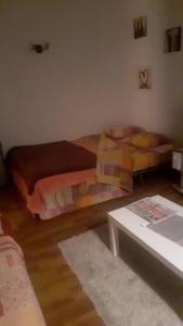 a living room with two beds and a table at Charmant studio in Grosseto-Prugna