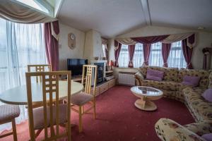 a living room with a couch and a table at Brilliant Caravan For Hire At Manor Park In Hunstanton Norfolk Ref 23176k in Hunstanton