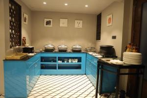 a kitchen with a blue island in a kitchen at Hotel Bluestone Nehru Place by The Cosy Hotels in New Delhi