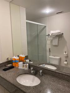 encimera con lavabo y espejo en Flat Aeroporto de Congonhas, en São Paulo