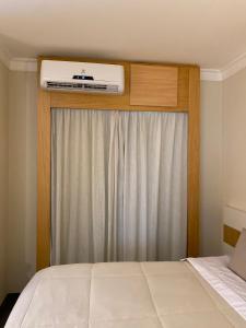 1 dormitorio con 1 cama y ventana con aire acondicionado en Flat Aeroporto de Congonhas, en São Paulo