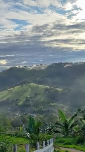 a view of a foggy valley with a white fence at Pousada do Sossego in Extrema