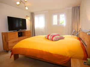 una camera con letto giallo e televisore di Ferienhaus in Krusendorf a Krusendorf