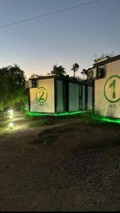 une maison avec des lumières vertes sur son côté dans l'établissement Greenboxaparts, à Firmat