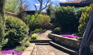 ogród z kamienną ścieżką i fioletowymi kwiatami w obiekcie Попската къща-възрожденски дух и съвременни удобства w mieście Medven