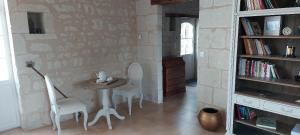 a room with a table and chairs and a book shelf at Chambre d'hôtes de l'Estrée in Lésigny