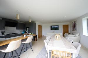 a kitchen and living room with a table and chairs at Rollestone New Forest (HOT TUB) in Salisbury