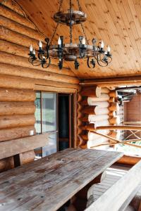 a dining table in a log cabin with a chandelier at Ray Eco Resort in Mukacheve