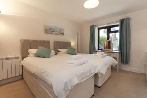 a bedroom with two beds and a window at The Brancaster in Blakeney