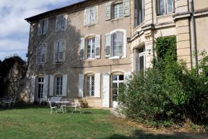 a building with a table and chairs in front of it at Chateau de Vaugelas - Charmant domaine près de Valence in Alixan