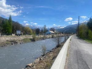 un fiume vicino a una strada accanto a una strada di Studio a Barcelonnette