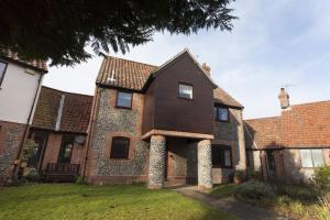 an old brick house with a black roof at The Kelling in Blakeney