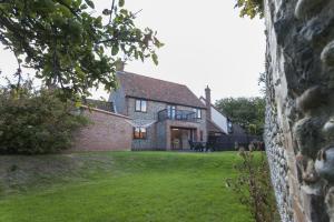 a large brick house with a lawn in front of it at The Kelling in Blakeney