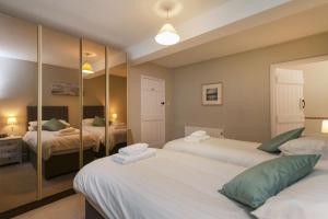 a bedroom with two beds and a mirror at Burnham A in Blakeney