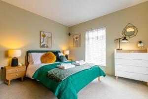 諾里奇的住宿－Corner Cottage，一间卧室配有一张带绿色棉被的床