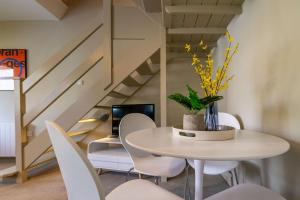 a dining room with a white table and chairs at Corner Cottage in Norwich