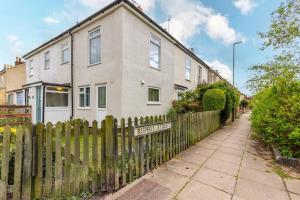 a wooden fence in front of a house at Corner Cottage in Norwich