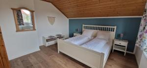 a bedroom with a white bed and a wooden ceiling at Ferienwohnung Friedrich in Michelstadt