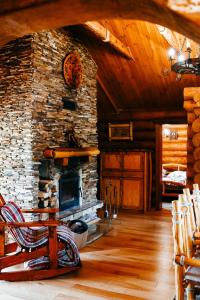 a living room with a stone fireplace in a cabin at Ray Eco Resort in Mukacheve