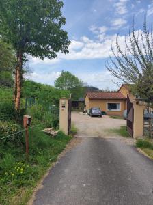 una entrada con una casa y un coche en la carretera en F2 EXTERIEUR LIT KING SIZE, en Brives-Charensac