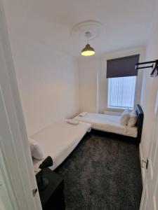 a small room with two beds and a window at Luna Apartments Newcastle Gateshead 1 in Gateshead
