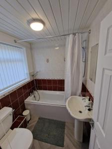 La salle de bains est pourvue d'une baignoire, de toilettes et d'un lavabo. dans l'établissement Luna Apartments Newcastle Gateshead 1, à Gateshead