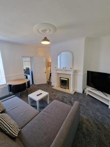 - un salon avec un canapé et une cheminée dans l'établissement Luna Apartments Newcastle Gateshead 1, à Gateshead