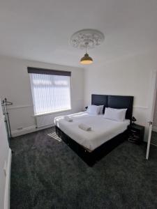 - une chambre dotée d'un grand lit avec des draps blancs et une fenêtre dans l'établissement Luna Apartments Newcastle Gateshead 1, à Gateshead